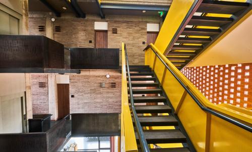 a staircase in a building with a yellow stair case at Alko Hotel Integrado in Cali