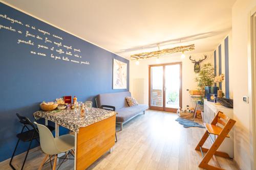 un salon avec un mur bleu et une table dans l'établissement La Tana del Coniglio, Comano Terme Holiday, à Comano Terme