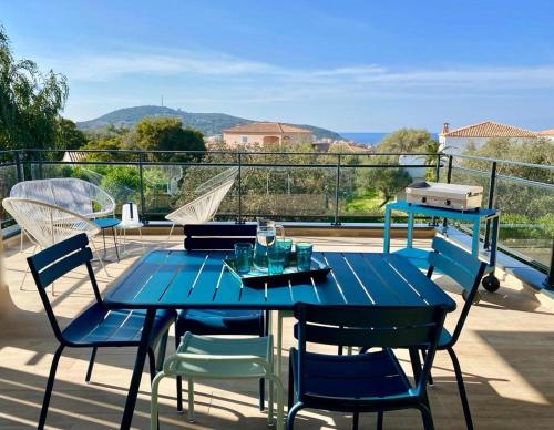 a blue table and chairs on a balcony at Résidence Storia d'Estate in LʼÎle-Rousse