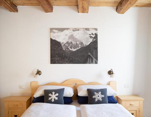 a bedroom with two beds and a picture on the wall at B&B SognoInCadore in Domegge di Cadore