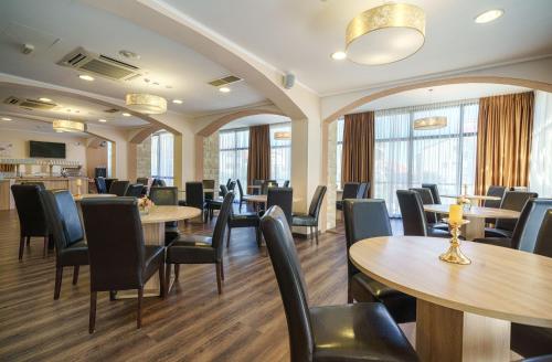 a dining room with tables and chairs and windows at Hotel Stella Maris - Style & Comfort in Vodice