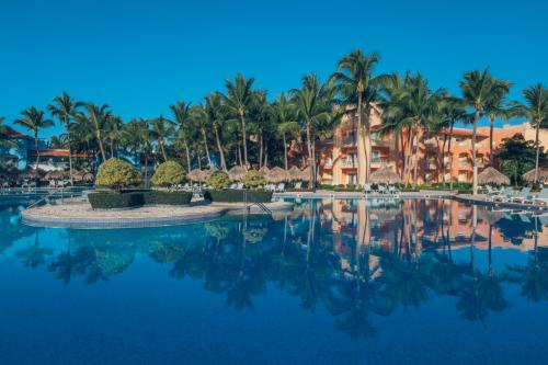 a pool at a resort with palm trees at Iberostar Selection Hacienda Dominicus in Bayahibe