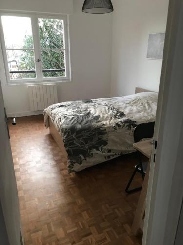 une chambre avec un lit, une fenêtre et une chaise dans l'établissement Appartement T3 Gilaldo, à Anglet