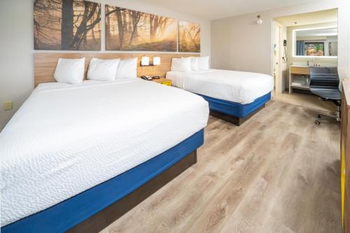 a hotel room with two beds and a desk at Days Inn by Wyndham Atlanta Stone Mountain in Stone Mountain