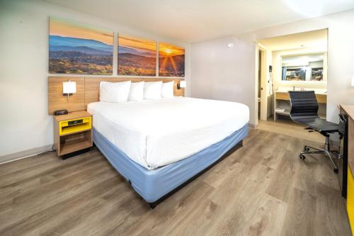 a hotel room with a bed and a desk at Days Inn by Wyndham Atlanta Stone Mountain in Stone Mountain