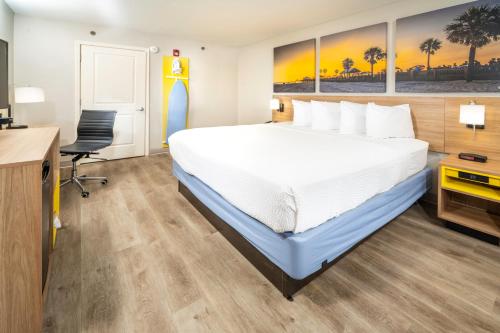 a hotel room with a large bed and a desk at Days Inn by Wyndham Atlanta Stone Mountain in Stone Mountain