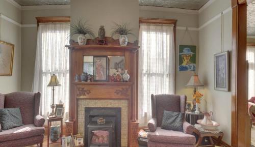 a living room with two chairs and a fireplace at Garden House Bed and Breakfast in Hannibal
