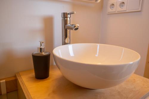 a bathroom with a white bowl sink and a faucet at Baumhaus im Herzen vom Unterallgäu in Erkheim