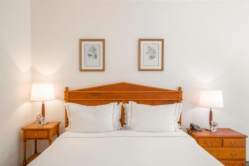 a bedroom with a large white bed with two night stands at Hotel Fazenda Dona Carolina in Itatiba