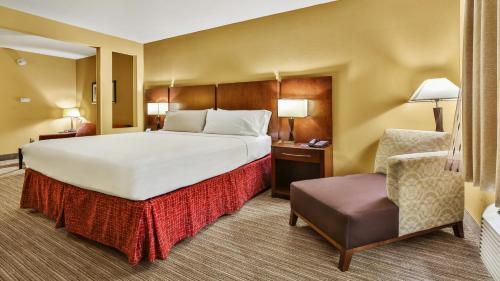 a hotel room with a large bed and a chair at Holiday Inn Express & Suites Houston South - Near Pearland, an IHG Hotel in Houston