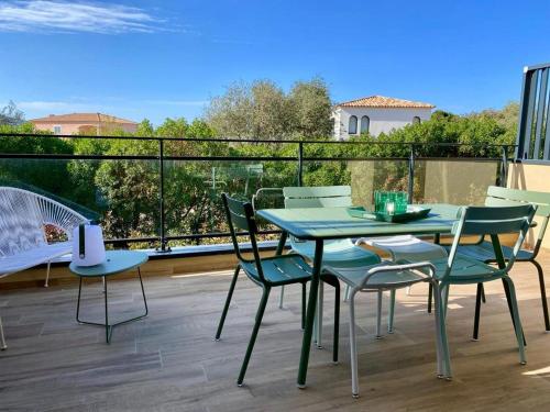 a table and chairs on a patio with a balcony at Résidence Storia d'Estate in LʼÎle-Rousse