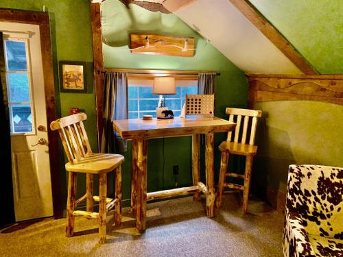 een kamer met een houten tafel en 2 stoelen bij Grunberg Haus Inn & Cabins in Waterbury