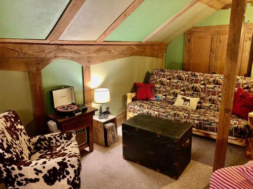 Grunberg Haus Inn & Cabins في واتربوري: غرفة معيشة مع أريكة وكرسي