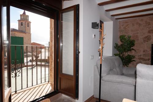 a room with a balcony with a couch and a window at La Casa El Cura in Campillo de Dueñas