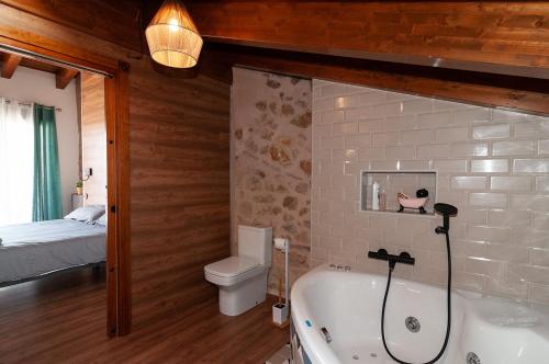a bathroom with a tub and a toilet and a bed at La Casa El Cura in Campillo de Dueñas