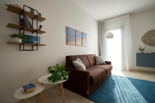 a living room with a brown couch and a table at Il Piccolo Albero in Scardovari