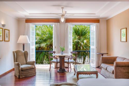 a living room with a table and chairs and large windows at Hotel Fazenda Dona Carolina in Itatiba