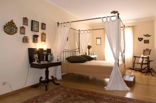 ein Schlafzimmer mit Himmelbett und Tisch in der Unterkunft Casa do Castanheiro in Reboreda
