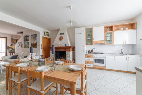 a kitchen and living room with a wooden table and chairs at Donoratico Comfort and Relax on the Etruscan Coast in Donoratico