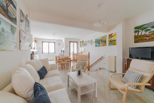 a living room with a white couch and chairs at Donoratico Comfort and Relax on the Etruscan Coast in Donoratico