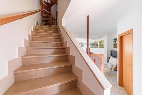 a staircase in a home with white walls and wooden floors at Donoratico Comfort and Relax on the Etruscan Coast in Donoratico