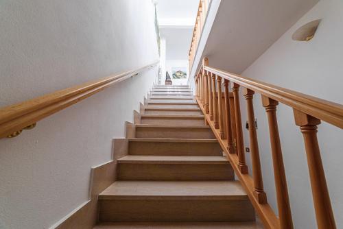 a staircase in a home with wooden railings at Donoratico Comfort and Relax on the Etruscan Coast in Donoratico