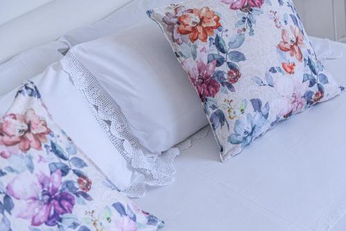 a bed with two pillows and a floral pillow at Donoratico Comfort and Relax on the Etruscan Coast in Donoratico