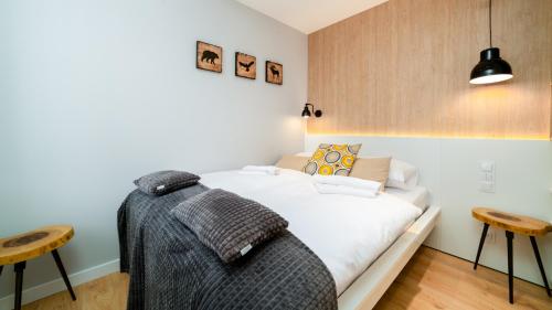 a bedroom with a bed and two stools at Triventi Mountain Residence Apartament Sunrise in Karpacz