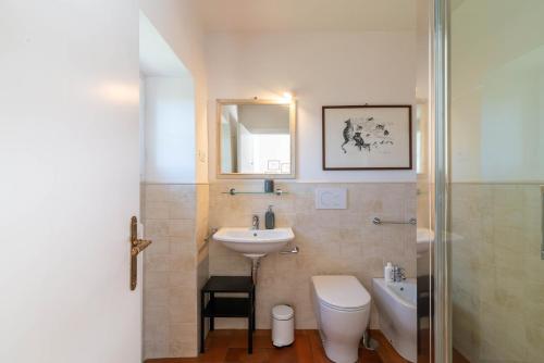 uma casa de banho com um lavatório, um WC e um espelho. em IV Casale Roma Country Villa em Prima Porta