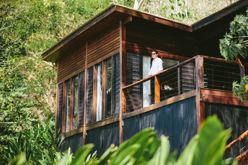 a man standing on the balcony of a tree house at The Remote Resort in Nawi