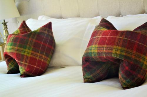 three pillows sitting on top of a bed at Craigellachie Lodge in Craigellachie