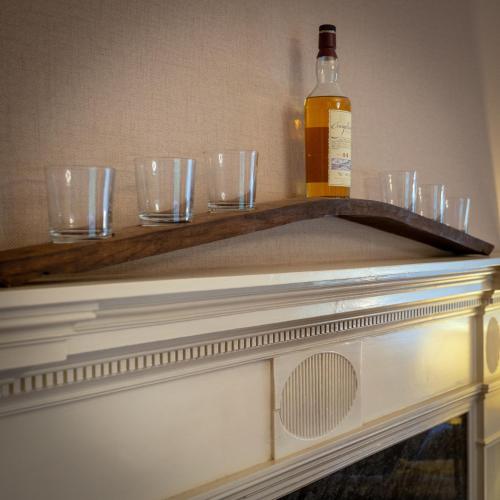 a table with glasses and a bottle on top of it at Craigellachie Lodge in Craigellachie