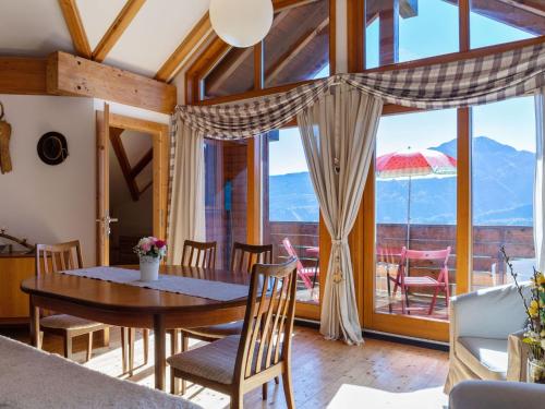 une salle à manger avec une table, des chaises et une grande fenêtre dans l'établissement Apartment in Sankt Stefan near Lake Pressegger, à Tratten