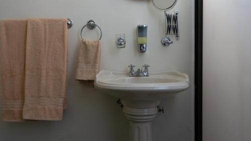 a bathroom with a white sink and towels at El Jardín del Edén B&B Boutique in Cuernavaca