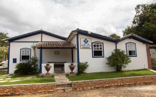 a white house with a blue roof at Pousada Villa Bia in Pirenópolis