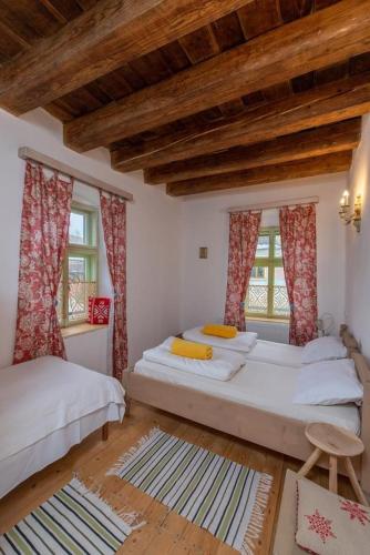 a bedroom with two beds and two windows at Casa Eva Wagner - Biertan in Biertan