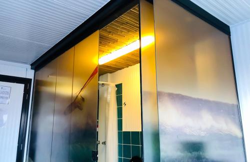 Puerta de cristal de un baño con ventana en Surfari Punta Rocas en Punta Negra