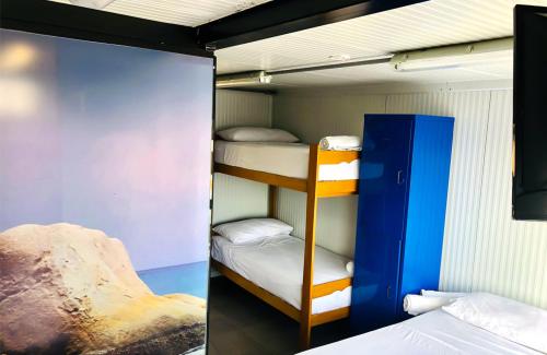 Zimmer mit Etagenbett und 2 Etagenbetten. in der Unterkunft Surfari Punta Rocas in Punta Negra