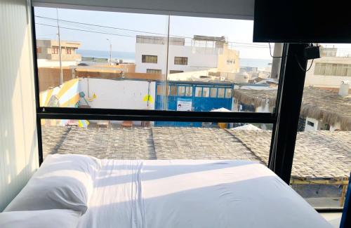 a bedroom with a view of a city from a window at Surfari Punta Rocas in Punta Negra