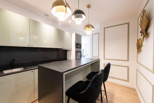 a kitchen with two black chairs at a counter at Beaubois in Paris