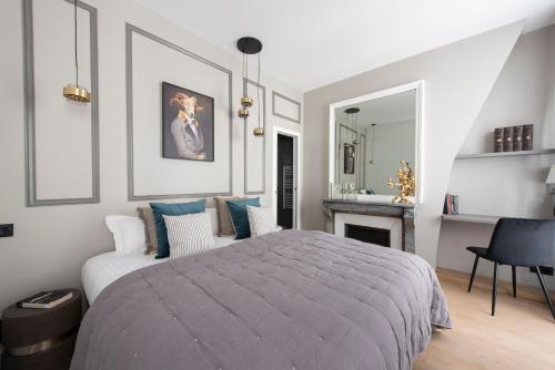 a bedroom with a large bed and a fireplace at Beaubois in Paris