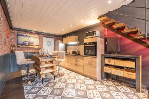 une cuisine avec une table, des chaises et un comptoir dans l'établissement Loft industriel en centre ville, au Puy-en-Velay