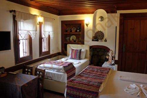 a bedroom with two beds and a table in a room at Avcıoğlu Konak Otel in Safranbolu