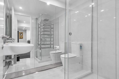 ein Badezimmer mit Toilette, Waschbecken und Dusche in der Unterkunft QV Stays Upscale Modern Viaduct Haven in Auckland
