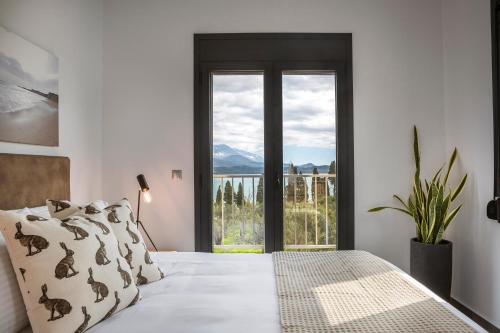 a bedroom with a bed and a large window at Ionian Village in Lixouri
