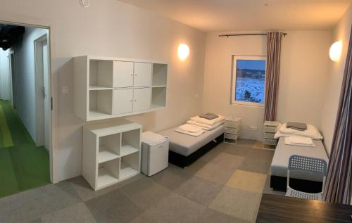 Pokój z 2 łóżkami i półkami oraz oknem w obiekcie Komarowo77 