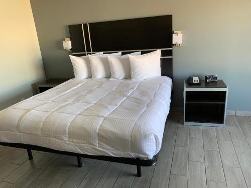 a bed with white sheets and pillows in a room at South Padre Island Lodge in South Padre Island