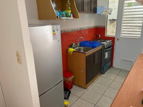 a kitchen with a refrigerator and a sink at Departamento amoblado por día in Arica