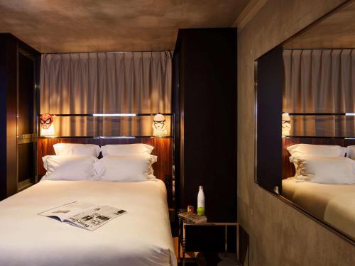 
a hotel room with two beds and two lamps at Mama Shelter Paris East in Paris
