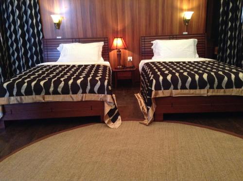two beds in a hotel room with two lamps at AA Lodge Maasai Mara in Talek